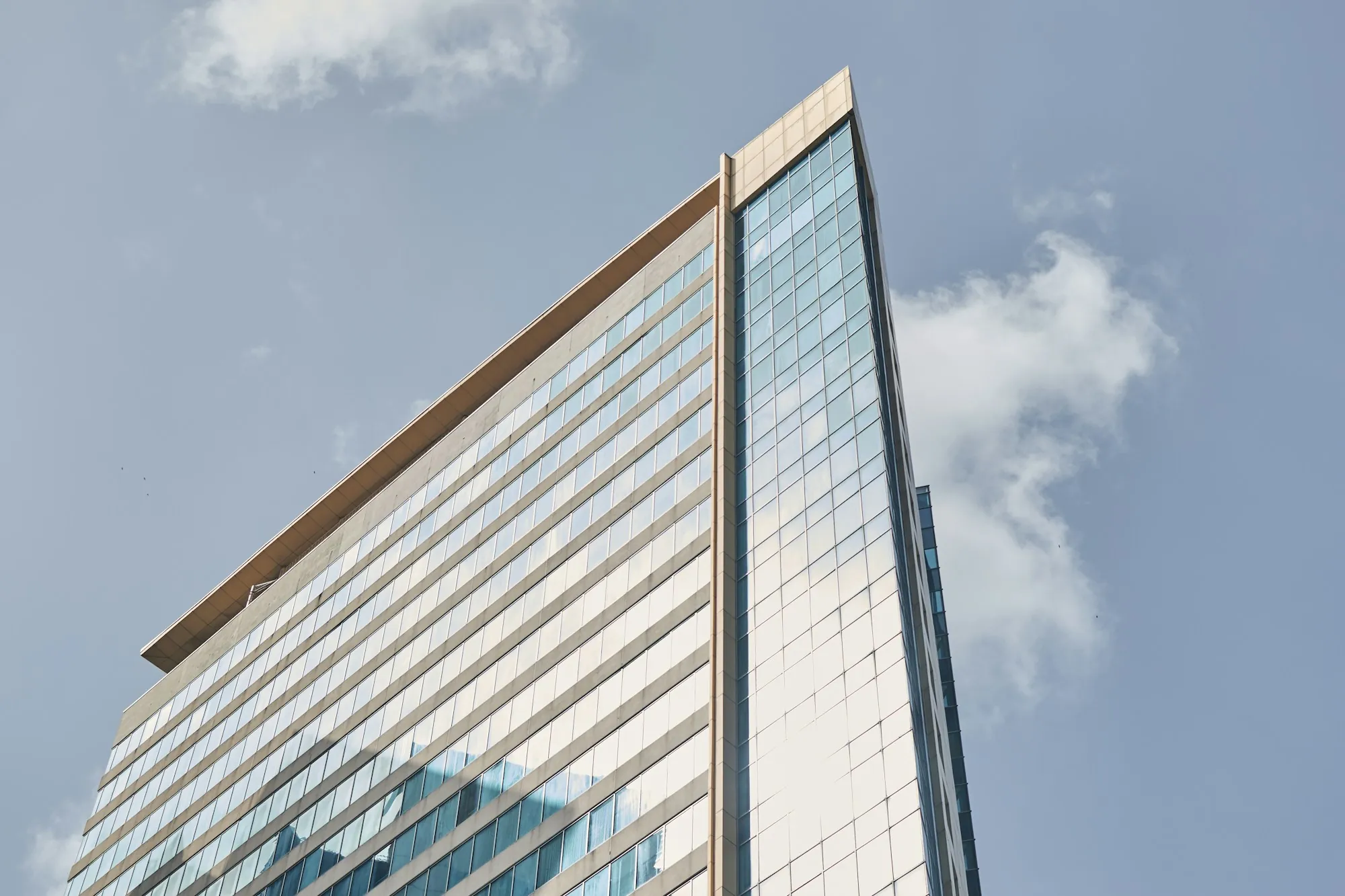 Modern office building corner with a glass facade, representing investment property in a 1031 exchange timeline for Lamont, California owners