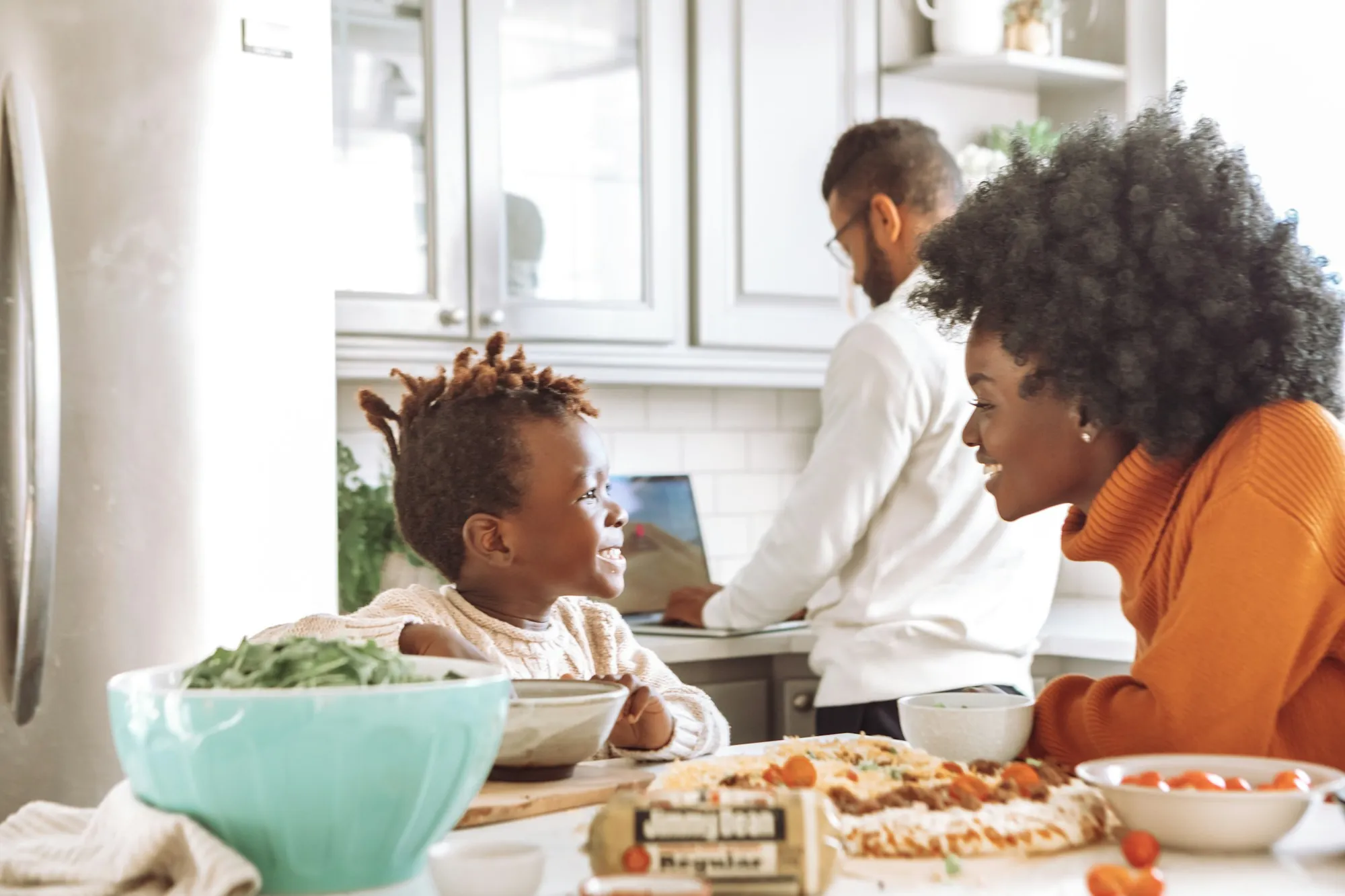 Parents and young son chatting at the kitchen counter